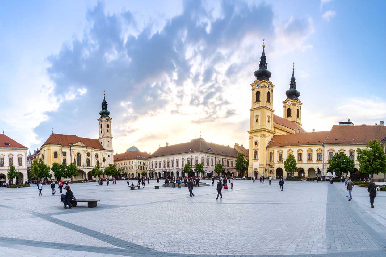 Komitat Vas - DSLR-Foto in professioneller Reportagequalität, Panoramaaufnahme vom Hauptplatz Szombathely, historische Fassaden, Menschen beim Flanieren, warmes Abendlicht, dokumentarischer Stil. Symbolbild