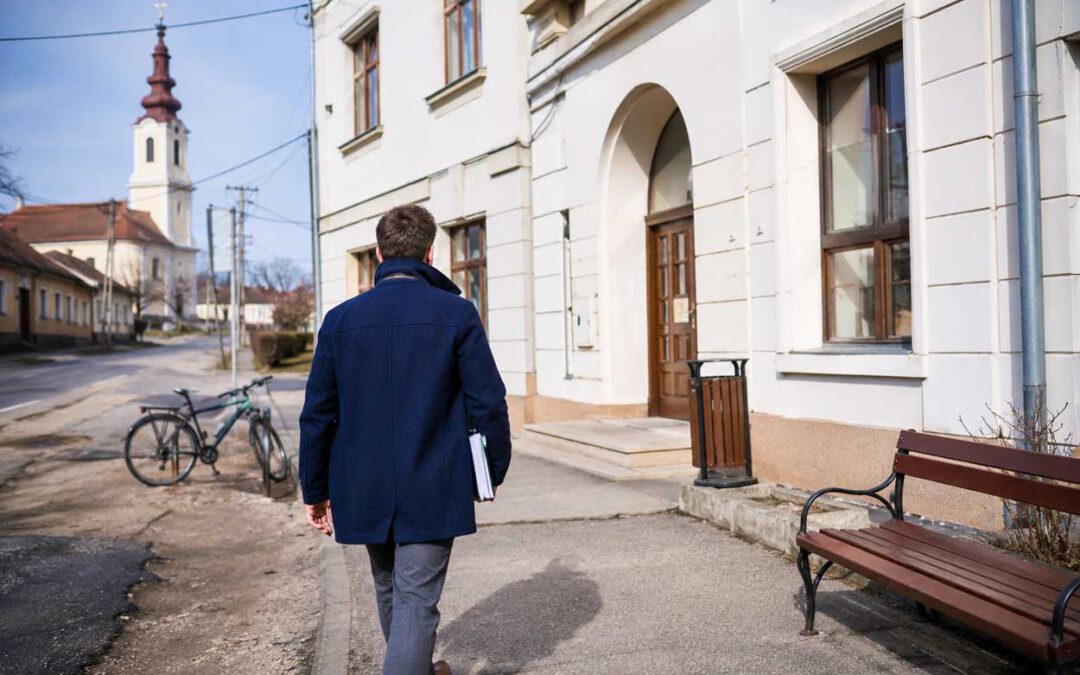 Auswandern nach Ungarn - Mann geht mit Dokumenten zu einem ungarischen Amtsgebäude im Komitat Tolna