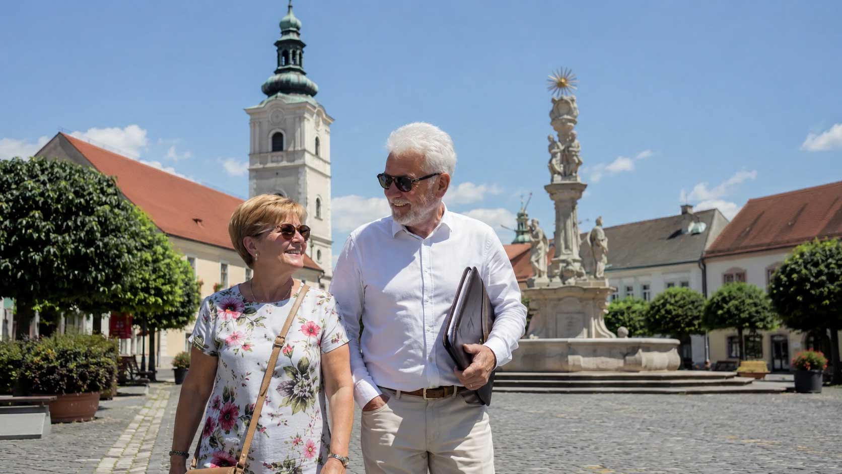 Rentnerpaar spaziert im Sommer durch eine ungarische Altstadt mit dem S1 Formular in der Dokumentenmappe zur Auswanderung nach Ungarn